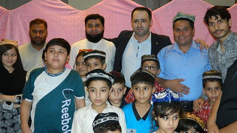 Omer Khan (2nd from R), founder of the Pakistan-based Omer Uyghur Trust, poses with Uyghur families and children living in Pakistan in November 2015. Photo Credit: RFA