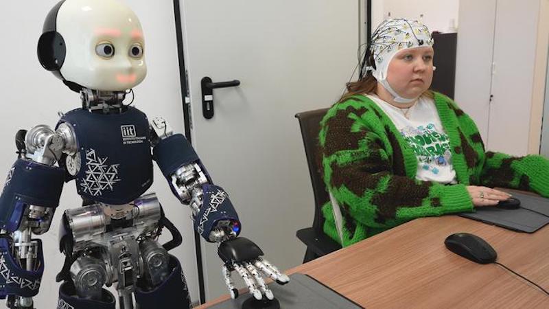 Researchers at the IIT (Italian Institute of Technology) have demonstrated that under specific conditions, humans can treat robots as co-authors of the results of their actions. Uma Navare, the first author of the paper ran the study using behavioral measures and neural responses registered by electroencephalography (EEG), to evaluate the emergence of a shared control mechanism between humans and the humanoid robot iCub. CREDIT: IIT-Istituto Italiano di Tecnologia