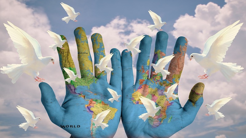 globe earth hands peace doves